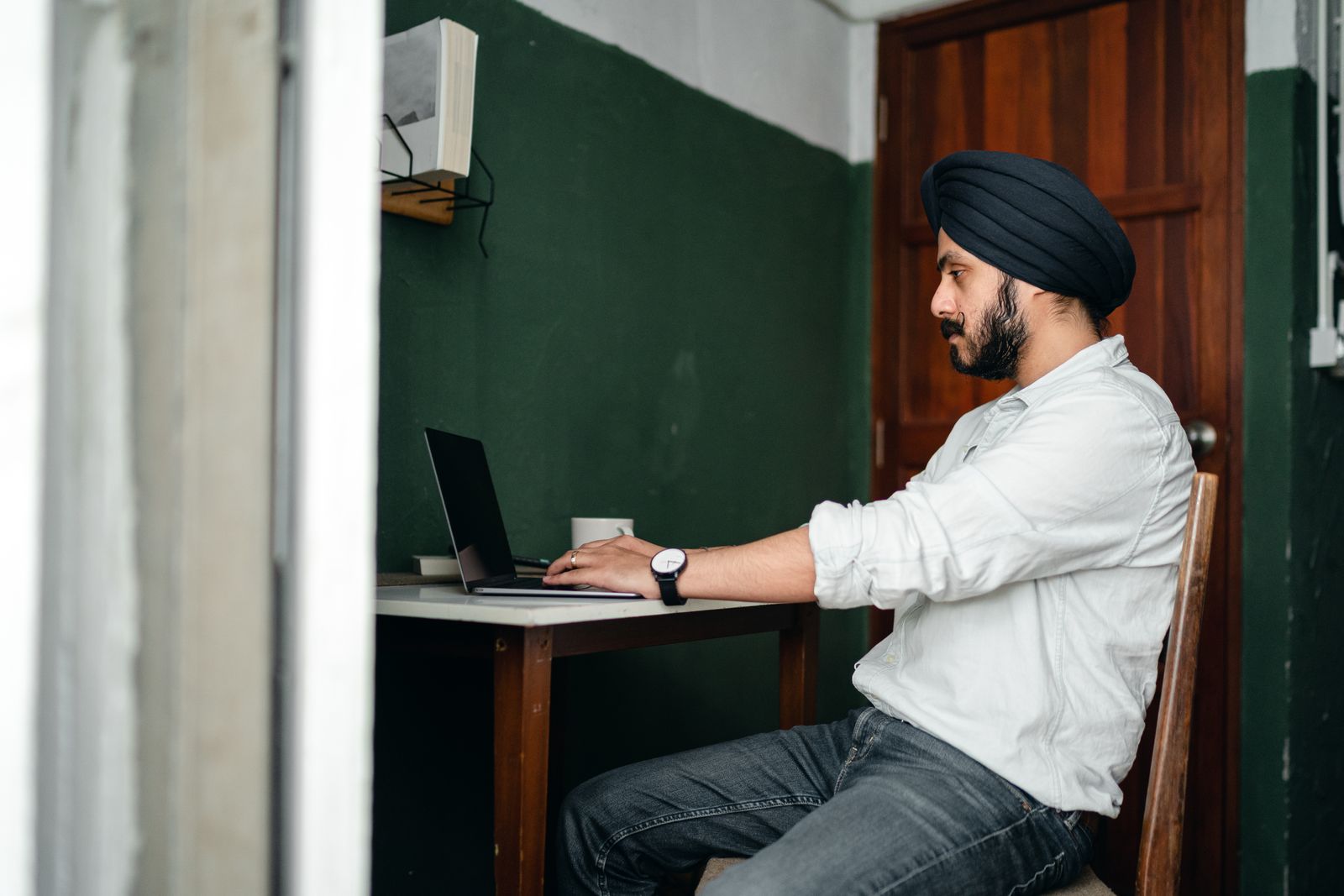 A focused person working alone on a laptop at a home desk