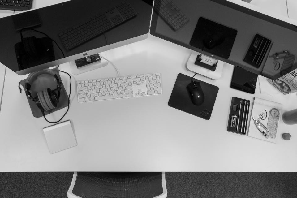 Top-down view of a dual-monitor workstation with keyboard, mouse and headphones