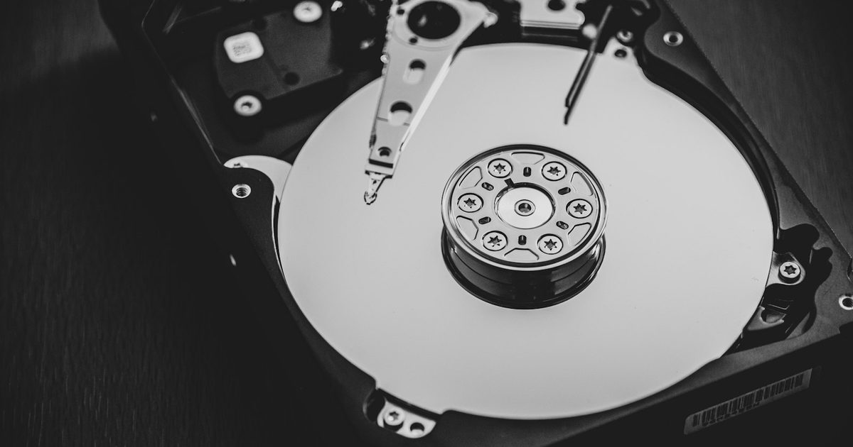 Un disque dur externe blanc et argenté posé sur un bureau