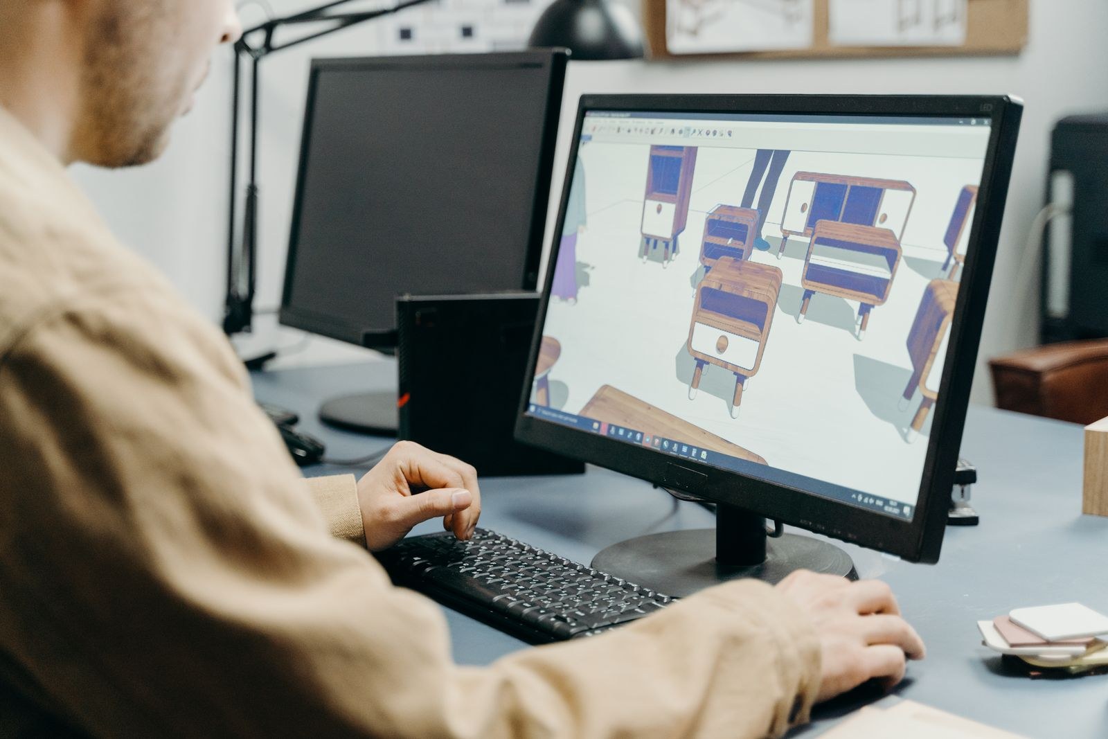 A designer working on 3D software at a computer