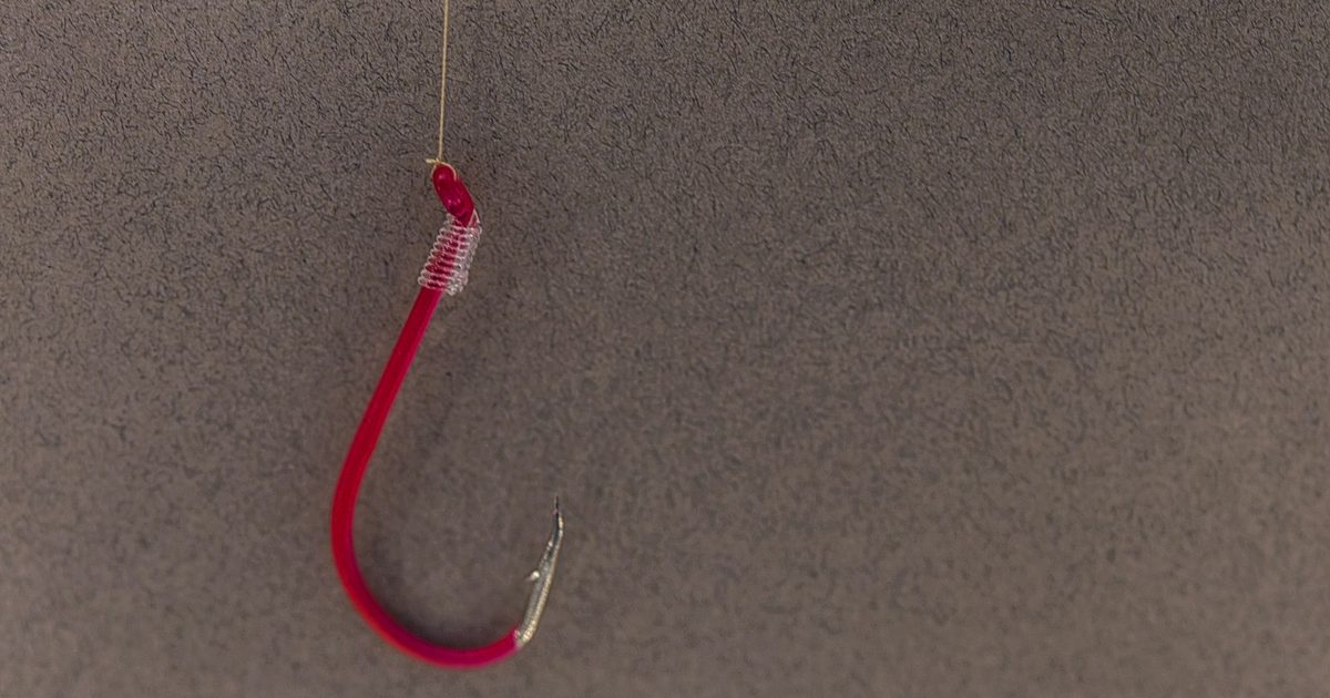 Gros plan d'un hameçon rouge, métaphore des attaques de phishing