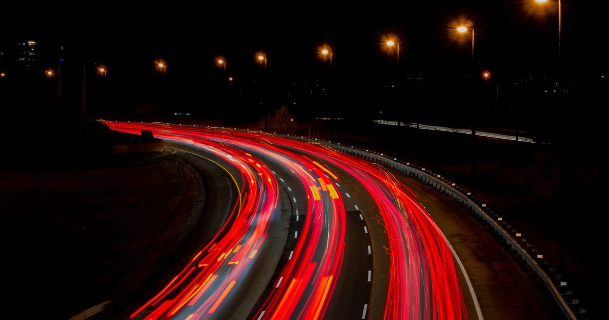 Long-exposure light trails from cars on a night road