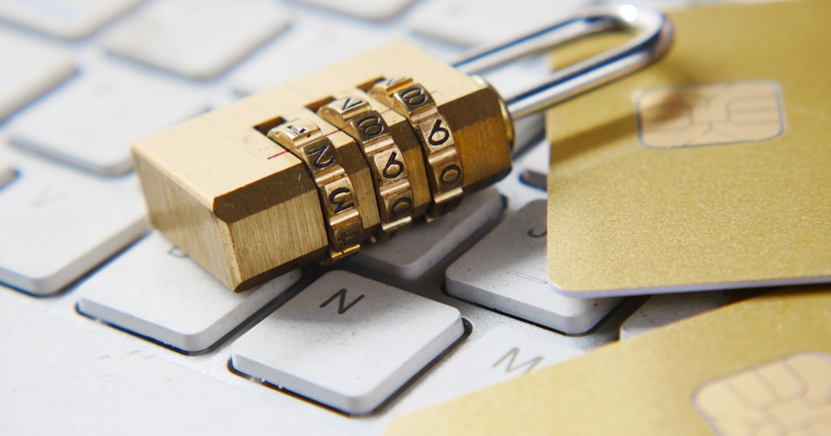 A golden padlock sitting on top of a computer keyboard, symbolizing digital authentication