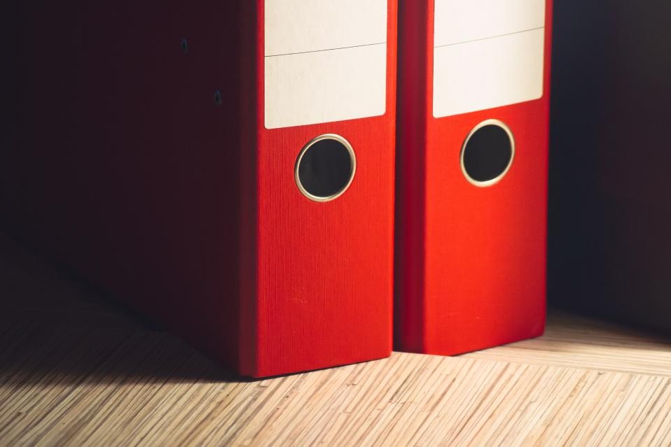 Red box files standing on a desk