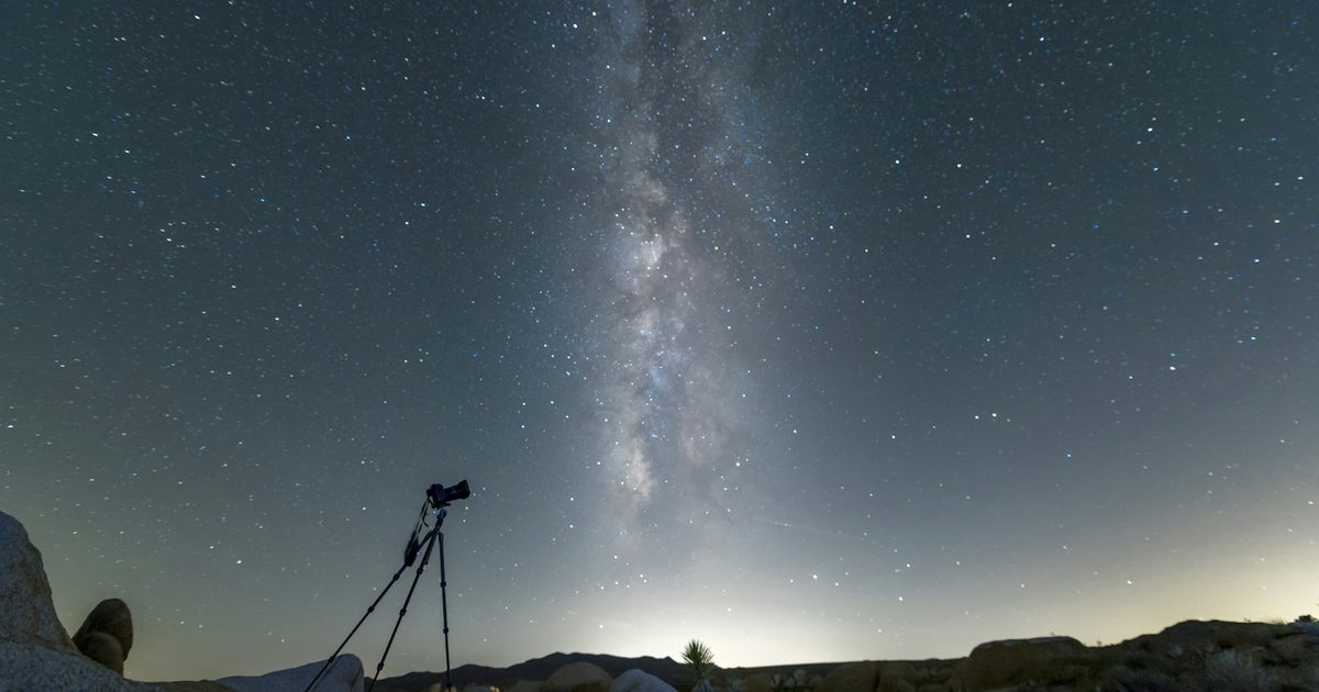 La silhouette d'un trépied photo sous un ciel nocturne étoilé