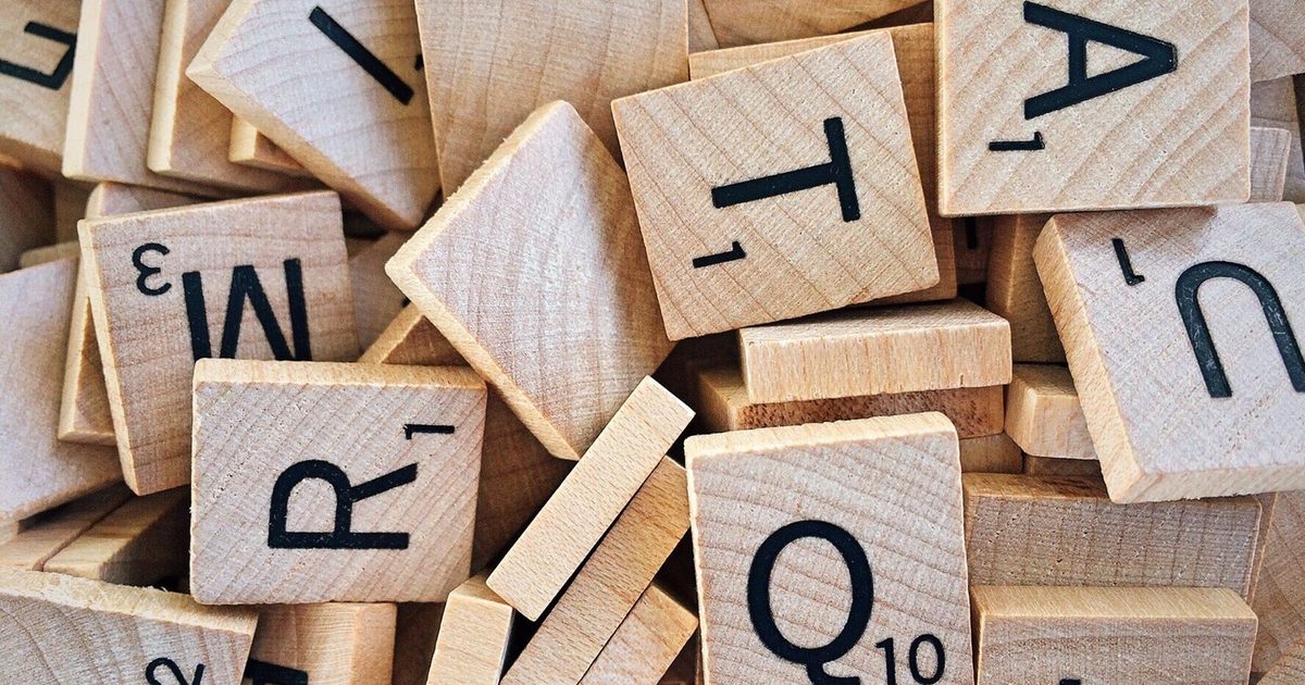 Wooden Scrabble letter tiles showing capital letters
