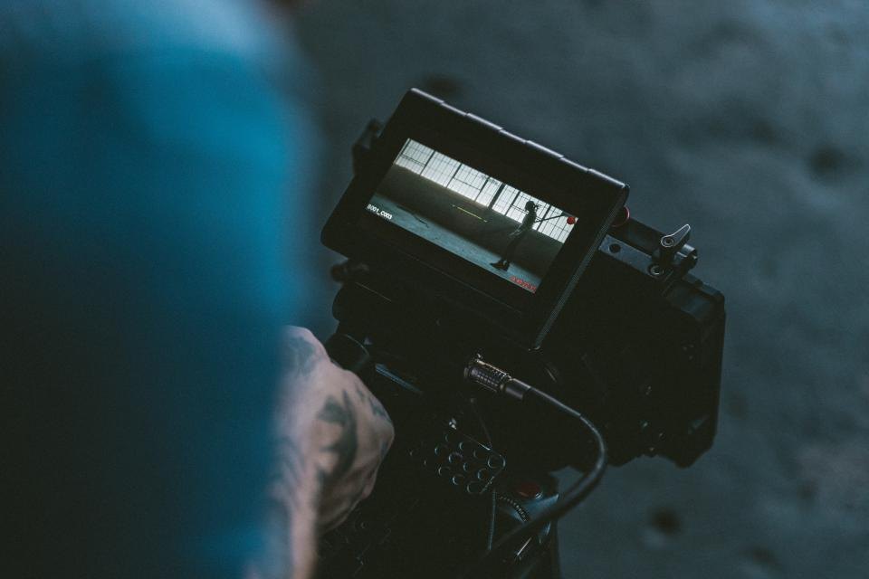 A filmmaker checking a shot on a video camera monitor